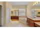 Bright bathroom featuring a soaking tub, vanities, and tile flooring at 11508 30Th E Cv, Parrish, FL 34219