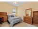 Comfortable bedroom with neutral walls, ceiling fan, and wooden dresser providing ample storage at 11508 30Th E Cv, Parrish, FL 34219