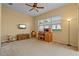 Large bedroom with carpet flooring, ceiling fan, and desk in a naturally lit space at 11508 30Th E Cv, Parrish, FL 34219