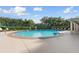 A community pool featuring a spacious deck, lounge chairs, and a covered seating area at 11508 30Th E Cv, Parrish, FL 34219