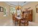 Dining room featuring a large bay window, a vintage chandelier and a wooden table set for six at 11508 30Th E Cv, Parrish, FL 34219