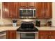 Close-up of stainless steel microwave, oven, and a well-organized countertop with essential appliances at 11508 30Th E Cv, Parrish, FL 34219
