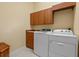 Well-lit laundry room featuring a sink, overhead cabinets and modern appliances at 11508 30Th E Cv, Parrish, FL 34219
