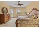 Bedroom with a large window view, king bed, dresser, and en-suite bathroom access at 11508 30Th E Cv, Parrish, FL 34219