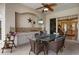 Outdoor kitchen and dining area with tile countertops, sink, TV, ceiling fan, and wicker furniture at 11508 30Th E Cv, Parrish, FL 34219