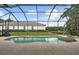 Screened-in pool and hot tub with an outdoor view of the lawn and trees at 11508 30Th E Cv, Parrish, FL 34219