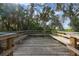 Wooden deck with benches offering a serene view of lush tropical foliage and trees at 11508 30Th E Cv, Parrish, FL 34219