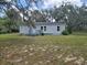 View of the home's exterior featuring a well-maintained yard and mature trees at 13023 Taylor St, Brooksville, FL 34613