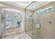 Bathroom showcasing a glass-enclosed shower, a soaking tub, and plantation shutters for natural light and privacy at 13203 Lost Key Pl, Lakewood Ranch, FL 34202