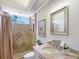 Bathroom featuring a shower with curtain and a vanity with a framed mirror; neutral tiling throughout at 13203 Lost Key Pl, Lakewood Ranch, FL 34202