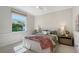 Bright bedroom showcasing a bed with throw blanket, window with blinds, and fresh neutral wall colors at 13203 Lost Key Pl, Lakewood Ranch, FL 34202