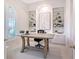 Bright home office with custom built-in shelving, modern art, and large arched window at 13203 Lost Key Pl, Lakewood Ranch, FL 34202