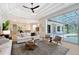 Bright living room with modern furniture and decor, open to kitchen and lanai with pool at 13203 Lost Key Pl, Lakewood Ranch, FL 34202