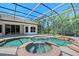 Inviting screened-in pool with attached spa, lush landscaping and expansive patio at 13203 Lost Key Pl, Lakewood Ranch, FL 34202