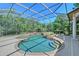 Inviting screened-in pool featuring an attached spa and lush landscaping at 13203 Lost Key Pl, Lakewood Ranch, FL 34202
