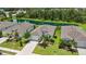 Aerial view of the home with well-manicured landscaping, a driveway, and a pond in the background at 13804 Woodbridge Ter, Lakewood Ranch, FL 34211