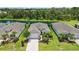 Aerial view of the home with well-manicured landscaping, a driveway, and a pond in the background at 13804 Woodbridge Ter, Lakewood Ranch, FL 34211
