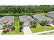 Aerial view of the home with well-manicured landscaping, a driveway, and a pond in the background at 13804 Woodbridge Ter, Lakewood Ranch, FL 34211