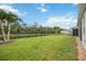 Expansive backyard with lush lawn, privacy fence, and views of tranquil pond at 13804 Woodbridge Ter, Lakewood Ranch, FL 34211