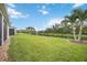 View of the fenced backyard with green grass and pond at 13804 Woodbridge Ter, Lakewood Ranch, FL 34211