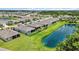 A serene backyard view with a well-kept lawn, a screen, and a community pond offering a relaxing outdoor space at 13804 Woodbridge Ter, Lakewood Ranch, FL 34211