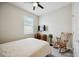 A carpeted bedroom with a ceiling fan, desk, rocking chair and a window for natural light at 13804 Woodbridge Ter, Lakewood Ranch, FL 34211