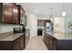A kitchen featuring a large island with granite countertops and dark wood cabinets at 13804 Woodbridge Ter, Lakewood Ranch, FL 34211