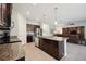 Kitchen with stainless appliances, granite counters, island, and seamless flow to living area at 13804 Woodbridge Ter, Lakewood Ranch, FL 34211
