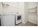 Clean laundry room featuring a modern washer and dryer set with shelving for storage at 13804 Woodbridge Ter, Lakewood Ranch, FL 34211