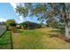 Large, grassy backyard featuring a screened lanai, privacy landscaping, and mature trees, perfect for outdoor enjoyment at 14901 17Th E Ave, Bradenton, FL 34212
