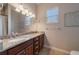 Bathroom with double sinks, granite counters, and a framed mirror at 14901 17Th E Ave, Bradenton, FL 34212