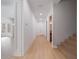 Hallway features hardwood floors, access to staircase, bathroom, and bright light from front door at 14901 17Th E Ave, Bradenton, FL 34212