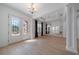 Bright living room boasts elegant chandelier, decorative wall mirror, and stunning hardwood floors at 14901 17Th E Ave, Bradenton, FL 34212