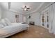 Spacious main bedroom with a ceiling fan, tv, wood floors, and access to a balcony at 14901 17Th E Ave, Bradenton, FL 34212