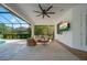 Covered outdoor patio boasts comfortable seating, ceiling fan, and views of the lush surroundings at 14901 17Th E Ave, Bradenton, FL 34212