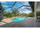 Enclosed pool and spa area features stone pavers, a screened enclosure, and views of the surrounding greenery at 14901 17Th E Ave, Bradenton, FL 34212