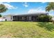 Wide backyard featuring a screened-in lanai and green lawn at 1498 Truval Ter, Port Charlotte, FL 33952