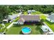 Aerial view of a home's backyard featuring a refreshing pool, screened-in patio and lush green space at 1498 Truval Ter, Port Charlotte, FL 33952