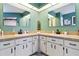 Elegant bathroom with dual sinks, white cabinetry, and decorative mirrors at 1498 Truval Ter, Port Charlotte, FL 33952