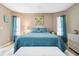 Cozy bedroom with a blue quilt, white wicker furniture, and beach-themed decor at 1498 Truval Ter, Port Charlotte, FL 33952