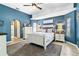 Cozy bedroom with blue accent wall, tray ceiling, and bright window lighting at 1498 Truval Ter, Port Charlotte, FL 33952