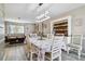 Elegant dining area with white chairs, laminate floors, and access to the living room area at 1498 Truval Ter, Port Charlotte, FL 33952