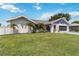 Attractive single-story home boasts a vibrant lawn, and attached garage, creating a welcoming exterior at 1498 Truval Ter, Port Charlotte, FL 33952