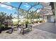 Screened-in lanai features stone flooring, comfortable seating and a view of the backyard at 1498 Truval Ter, Port Charlotte, FL 33952