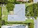 Aerial view of a single story home with a new grey roof surrounded by lush greenery and manicured lawns at 1541 Flower Dr, Sarasota, FL 34239
