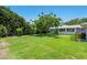 Expansive backyard with healthy lawn, a mature tree, and the home's exterior visible, great for outdoor activities at 1541 Flower Dr, Sarasota, FL 34239