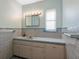 Bright bathroom featuring a sink with vanity, mirror with lighting, and a window with natural light at 1541 Flower Dr, Sarasota, FL 34239