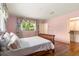 Bedroom showcasing hardwood floors, a large window with patterned curtains, and closet with shelving at 1541 Flower Dr, Sarasota, FL 34239