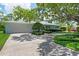 Well-kept single-story home showcasing a green lawn and mature shade trees over a driveway at 1541 Flower Dr, Sarasota, FL 34239