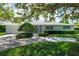 Attractive single-story home with a manicured lawn and shrubbery leading to a light-colored exterior at 1541 Flower Dr, Sarasota, FL 34239